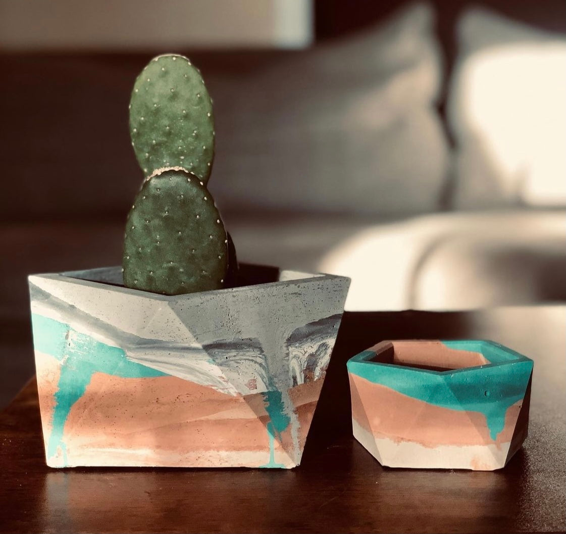 A Helena Planter, on the left, sits next to a large Cleo planter, on the right. Both are custom, handmade planters, created by Queen City ‘Crete.