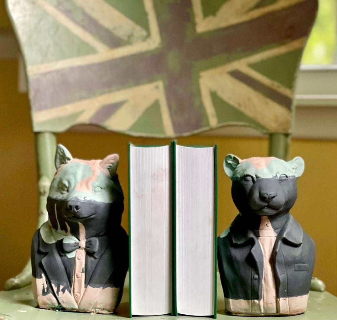 A pair of concrete bookends shaped like a wolf and a puma hold together a set of books. They were made by hand by Queen City ‘Crete. 